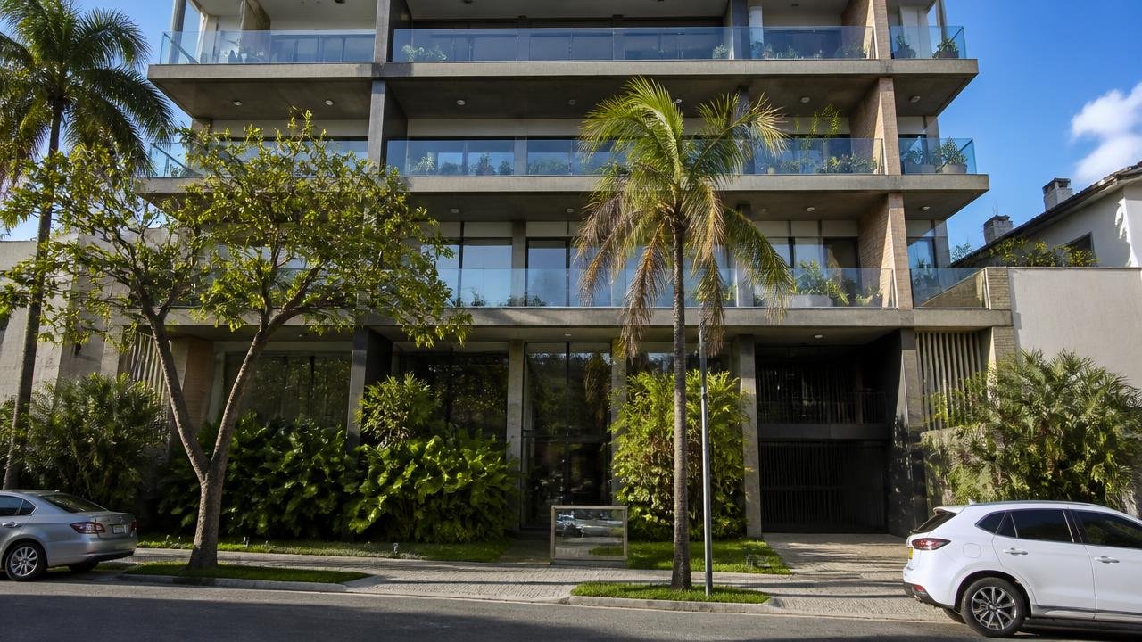 Fachada de edifício residencial recém-entregue em bairro litorâneo de Salvador, com varandas de vidro e paisagismo tropical